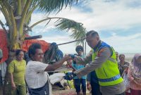 Kapolres Merauke AKBP Leonardo Yoga menyerahkan beras sumbangan kepada warga terdampak banjir rob, Selasa 13 Januari 2026.