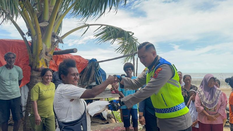 Kapolres Merauke AKBP Leonardo Yoga menyerahkan beras sumbangan kepada warga terdampak banjir rob, Selasa 13 Januari 2026.